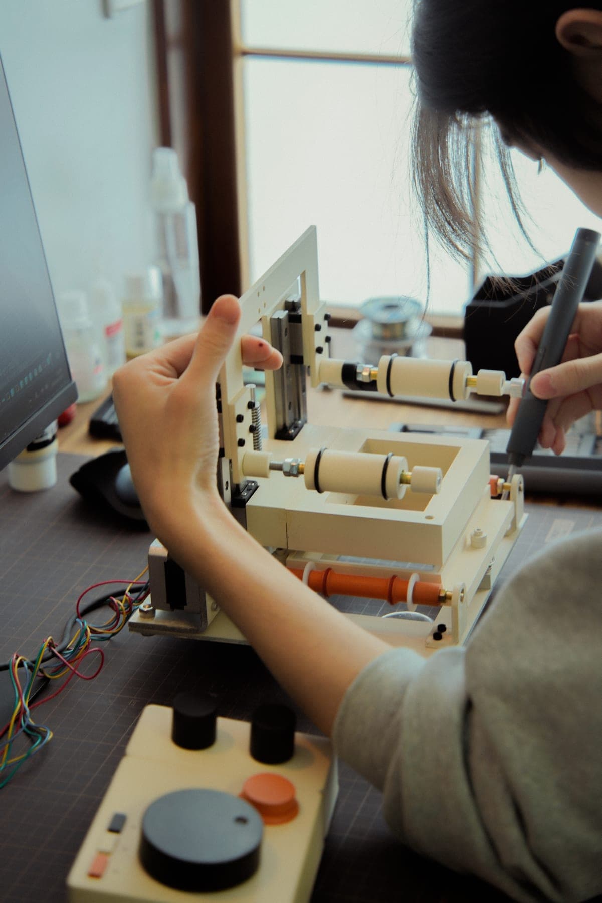 作業台で試作機を調整する手元